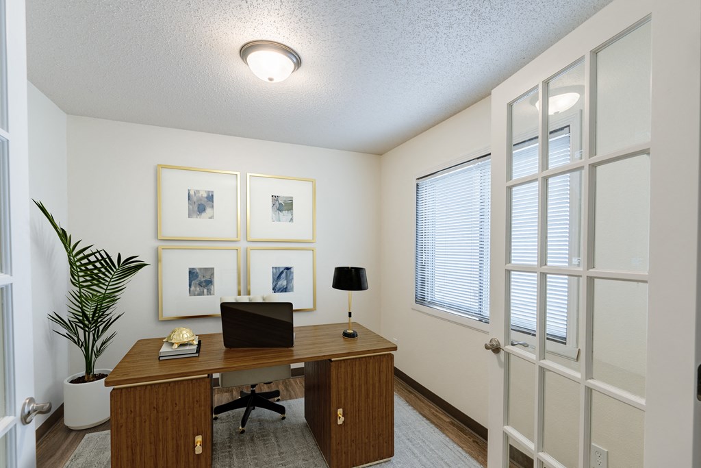 a den with a desk and window with French doors. Fargo, ND Willow Park Apartments