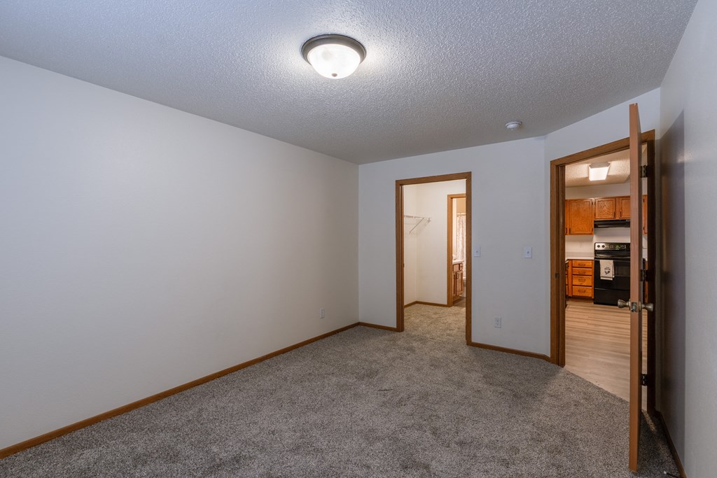 a bedroom with a walk in closet and bathroom. Fargo, ND Willow Park Apartments