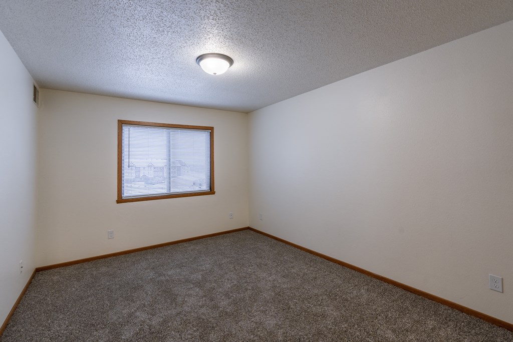 a bedroom with a window. Fargo, ND Willow Park Apartments