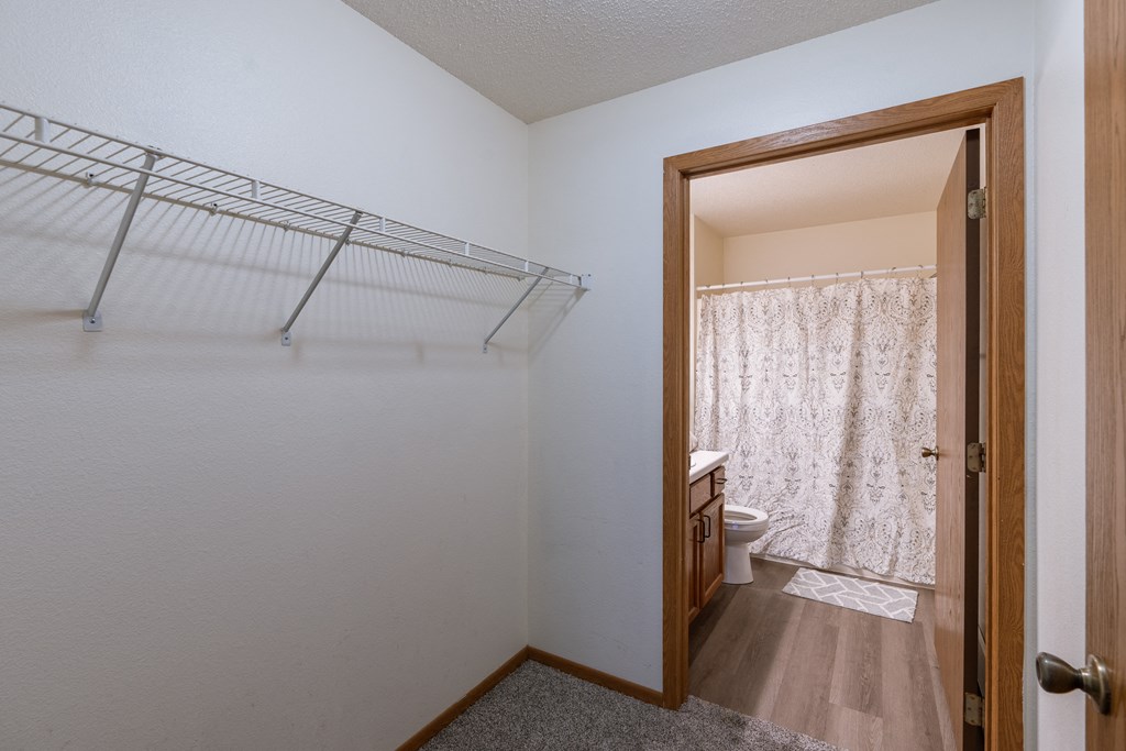 a closet with shelves and a bathroom attached. Fargo, ND Willow Park Apartments