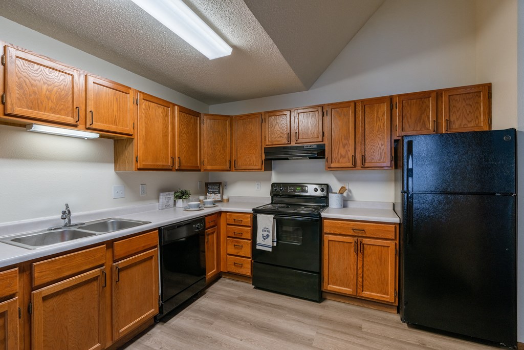 a kitchen with black appliances and white countertops. Fargo, ND Willow Park Apartments