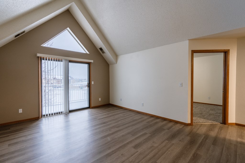 a living room with vaulted ceilings and large windows. Fargo, ND Willow Park Apartments
