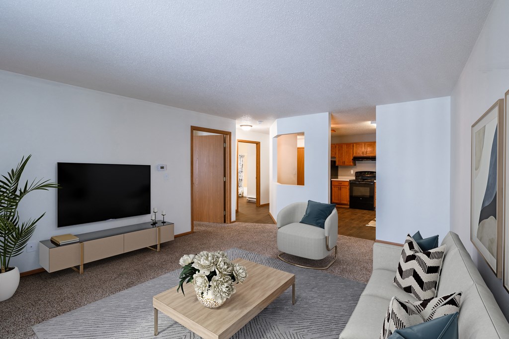 a living room with a couch and a coffee table and a television. Fargo, ND Willow Park Apartments