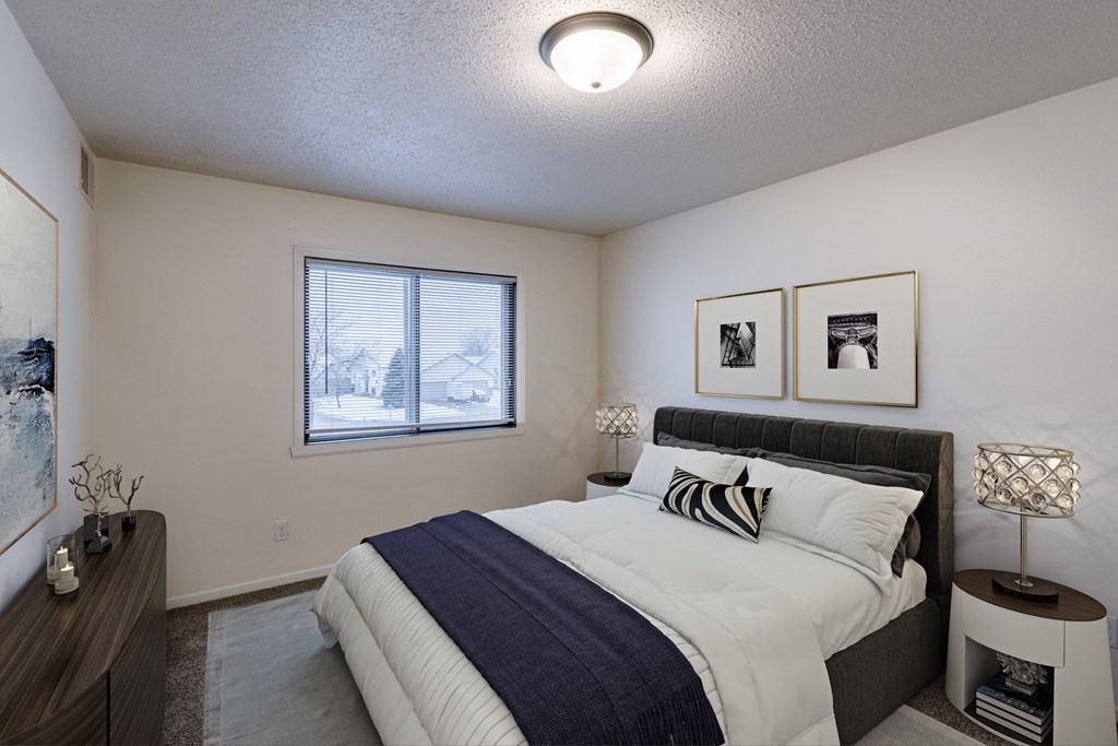 an empty bedroom with a bed and a window. Fargo, ND Willow Park Apartments
