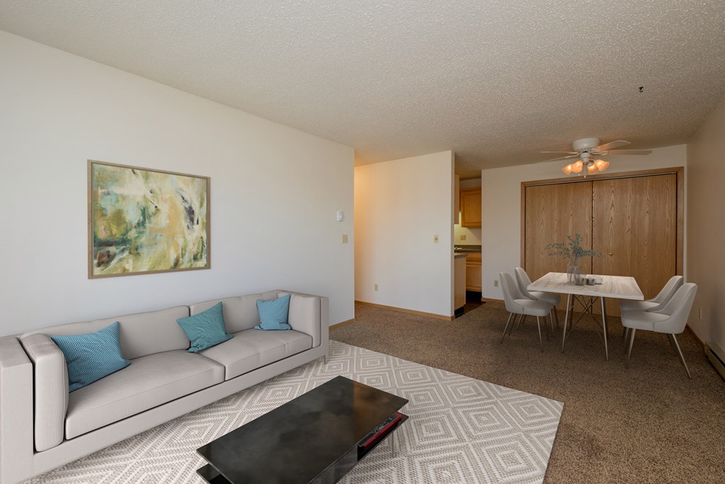Fargo, ND Windgate Apartments. a living room with a couch a table and a ceiling fan