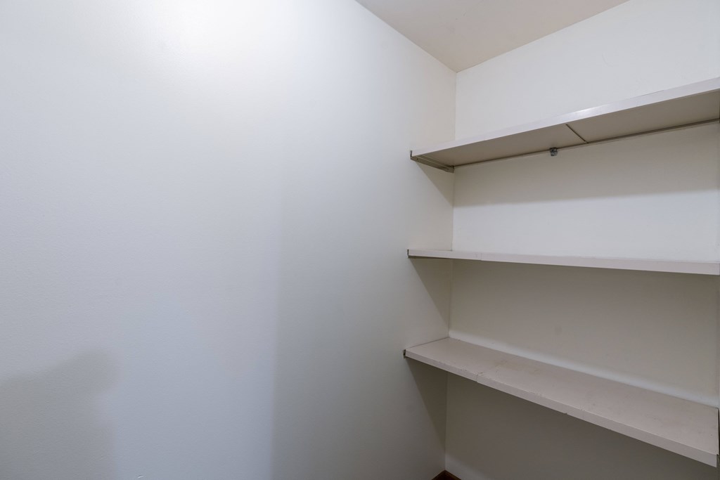 a room with white walls and shelves on the wall. Fargo, ND Windsor Apartments