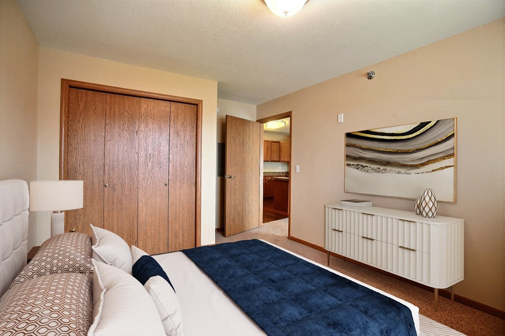 a bedroom with a bed and a closet and a bathroom. Fargo, ND Wolf Creek Apartments