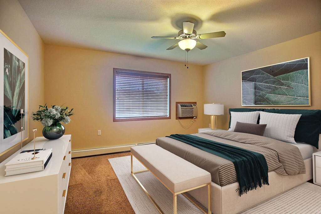 a bedroom with a bed and a ceiling fan. Fargo, ND Wolf Creek Apartments