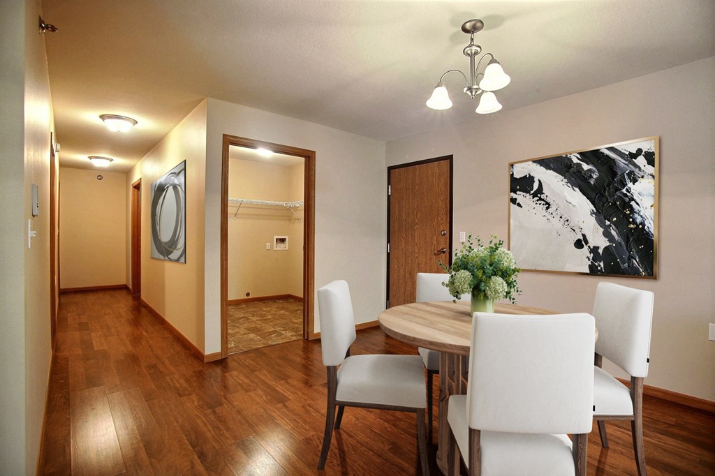 a dining room with a wooden table and white chairs. Fargo, ND Wolf Creek Apartments