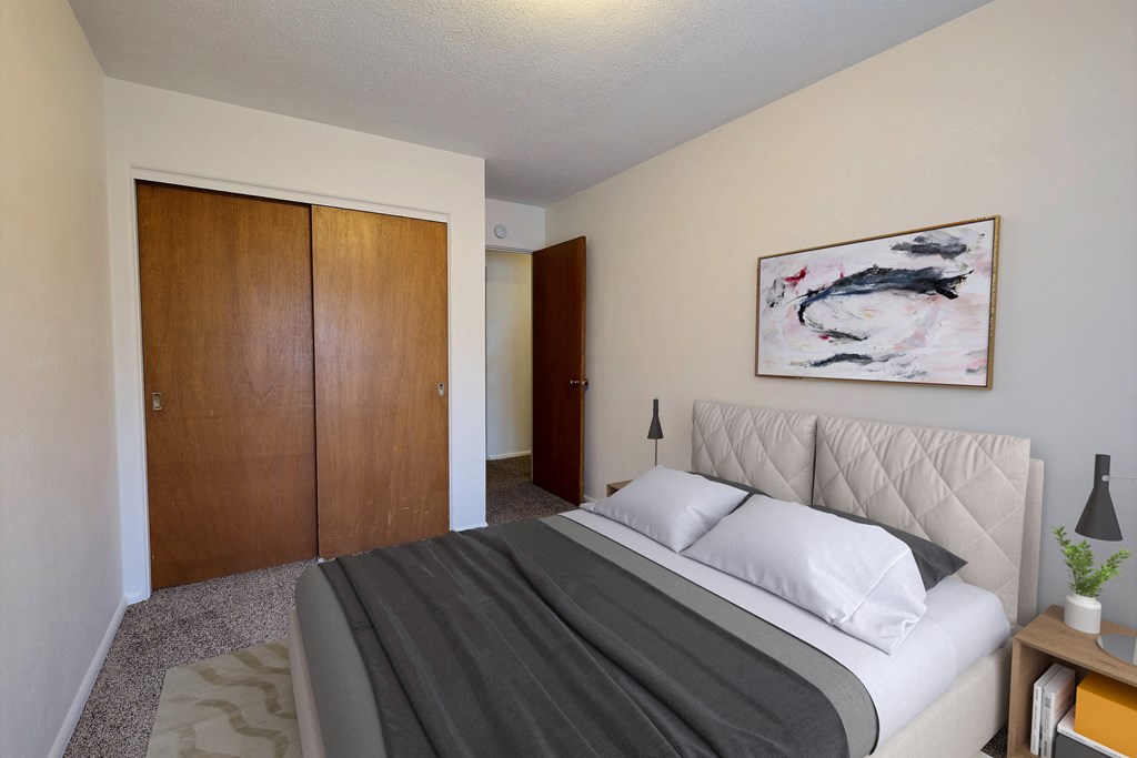 a bedroom with a bed and a closet. Fargo, ND Woodland Apartments