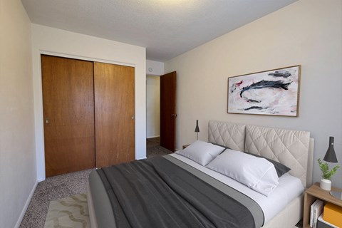 a bedroom with a bed and a closet. Fargo, ND Woodland Apartments