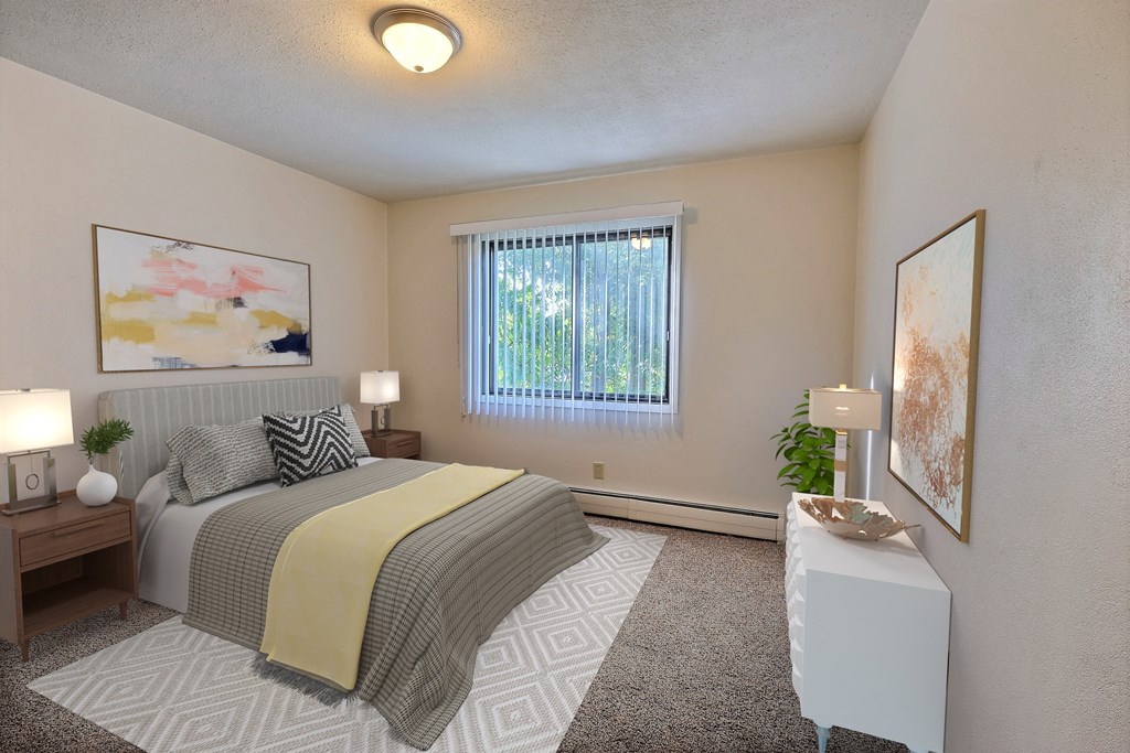 a bedroom with a bed and a window. Fargo, ND Woodland Apartments