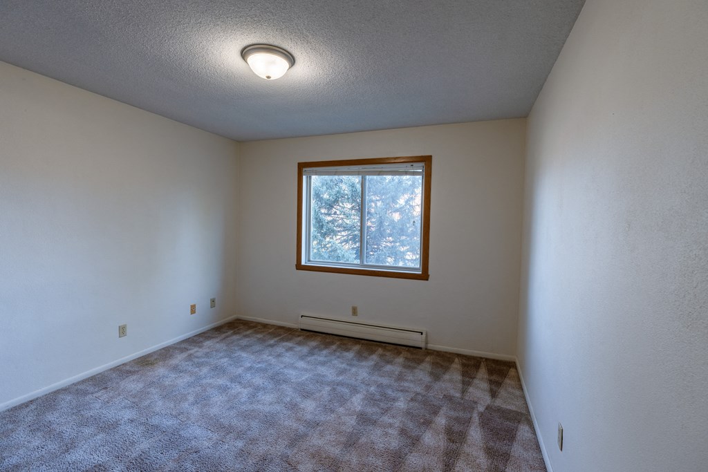 a bedroom of an empty house with a window