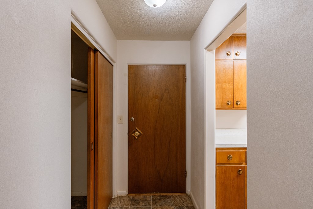a hallway with a door to a bathroom and a closet. Fargo, ND Woodland Apartments