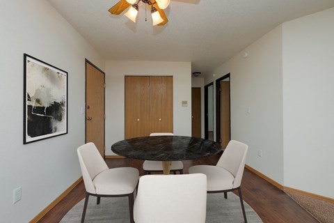 a dining room with a table and chairs. Moorhead, MN Woodstone Apartments