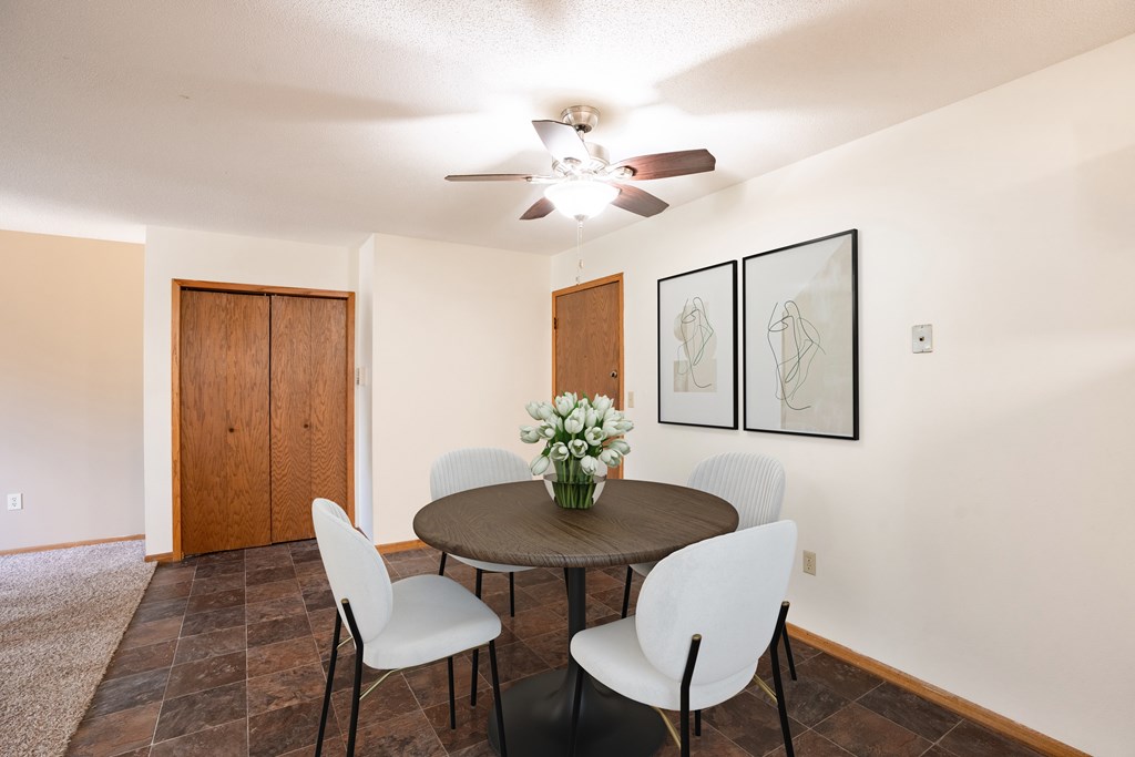 Fargo, ND Brookfield Apartments | 21A | Dining a dining room with a table and chairs and a ceiling fan.Fargo, ND Brookfield Apartments