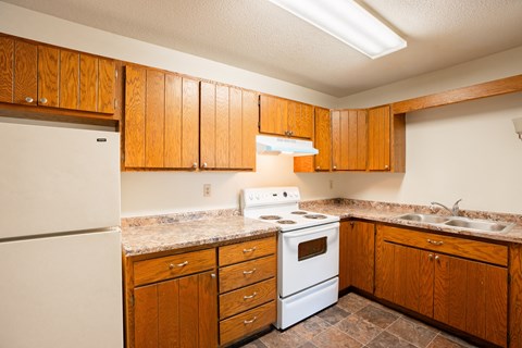 a kitchen with white appliances and wooden cabinets