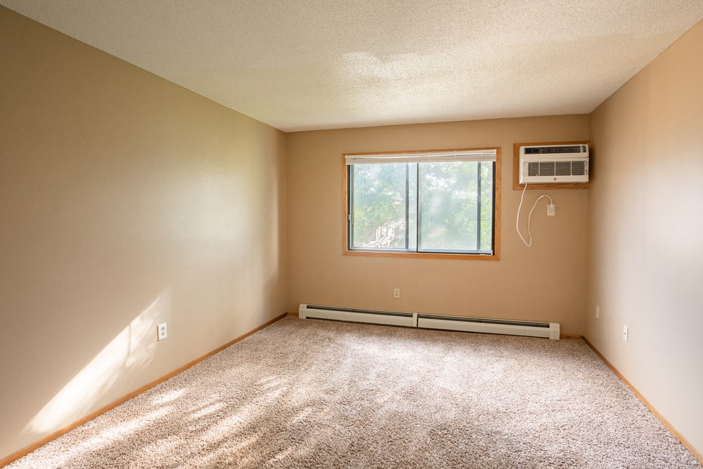 an empty room with a window and carpet. Fargo, ND Brookfield Apartments