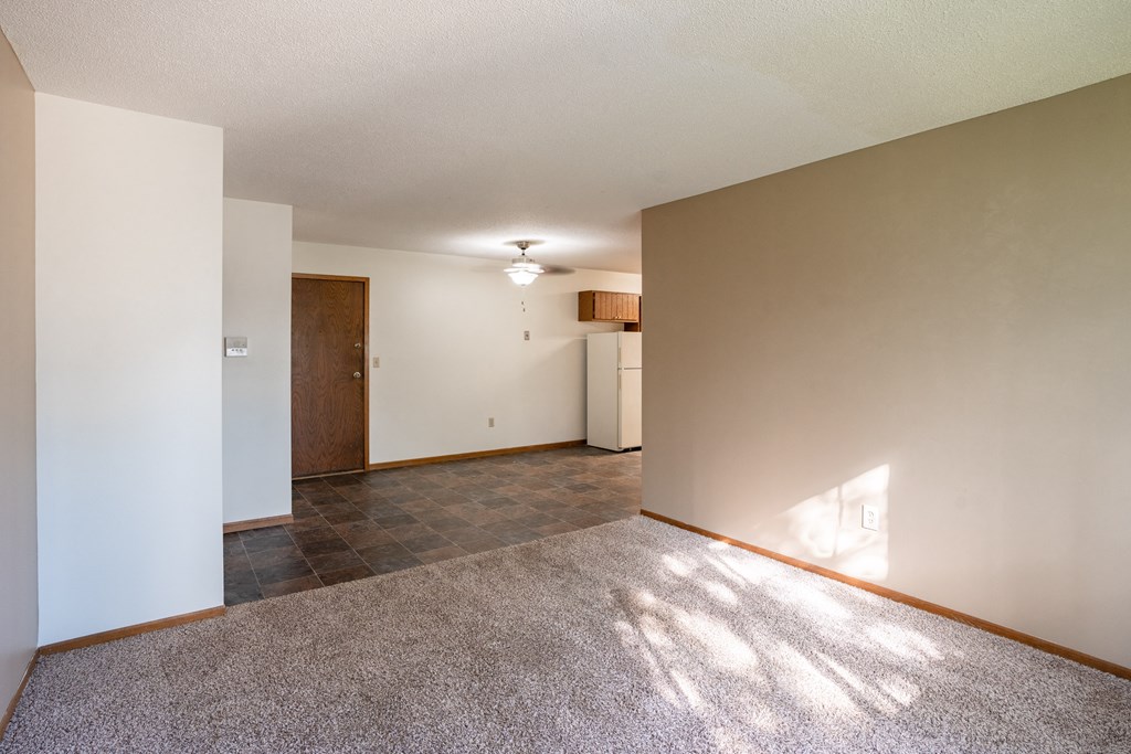 an empty living room with a tile floor and white walls. Fargo, ND Brookfield Apartments