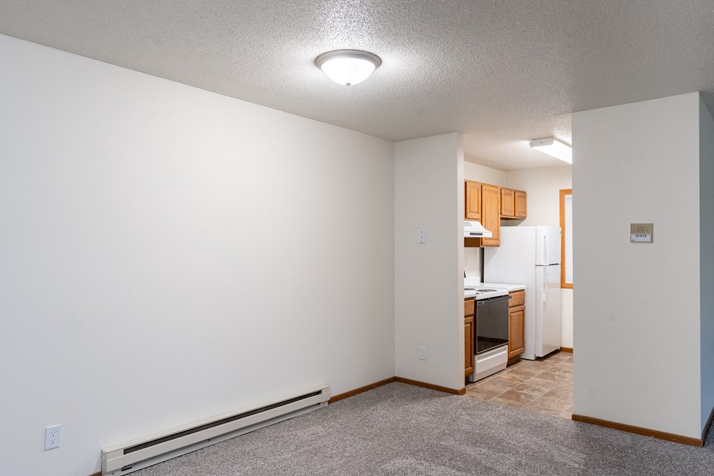 a dining room with a kitchen in the background. Fargo, ND Brownstone Apartments