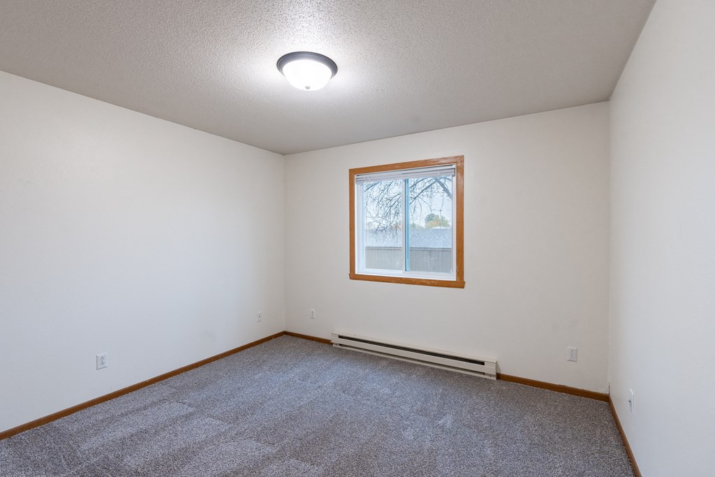 a bedroom with a window. Fargo, ND Brownstone Apartments