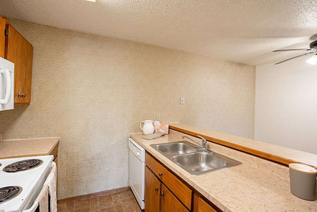 a kitchen with a sink and a stove. Fargo, ND Cedar Pointe Apartments