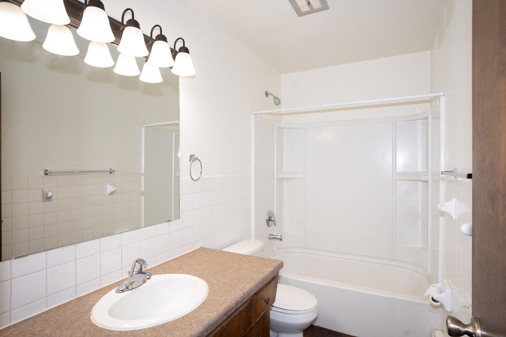 a bathroom with a sink and a shower and a toilet. Fargo, ND Country Club Apartments