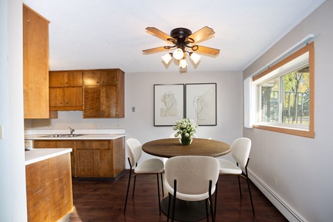 a kitchen with a table and chairs and a ceiling fan