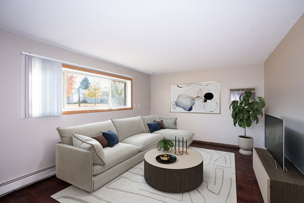 a living room with a white couch and a round coffee table.  Fargo, ND Country Club Apartments