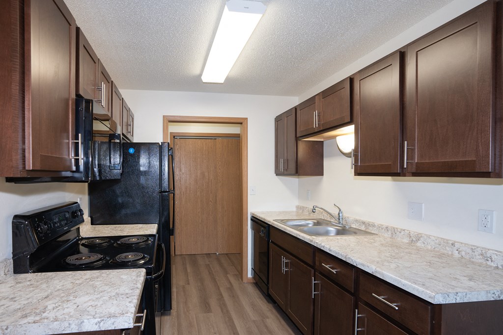 aa kitchen with black appliances. Fargo, ND Country Club Apartments
