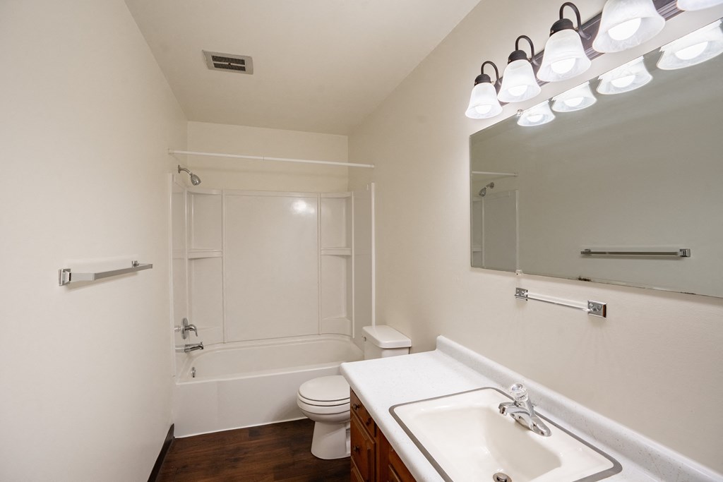 a bathroom with a sink and a toilet and a shower. Fargo, ND Crown Court 1 Apartments