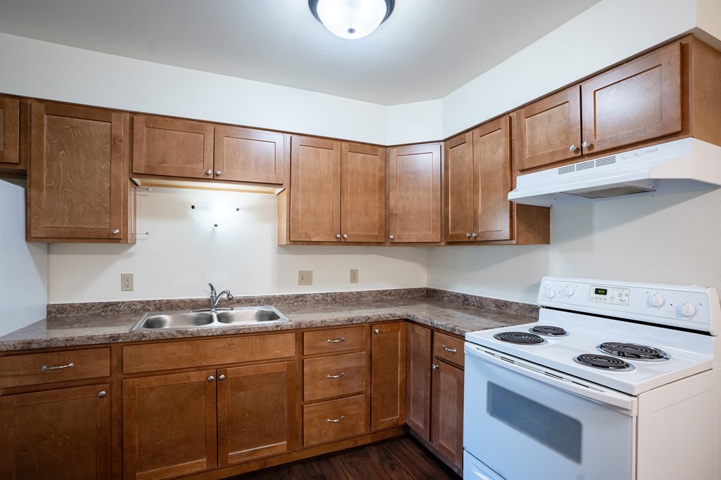 a kitchen with white appliances. Fargo, ND Crown Court 1 Apartments