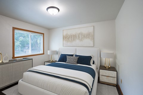a bedroom with a bed and two night stands and a window. Fargo, ND Crown Court 1 Apartments
