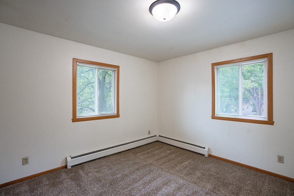 a bedroom with two windows. Fargo, ND Crown Court 1 Apartments