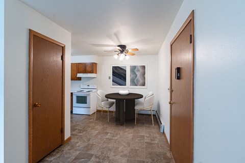 a kitchen and dining room with a small table and a ceiling fan