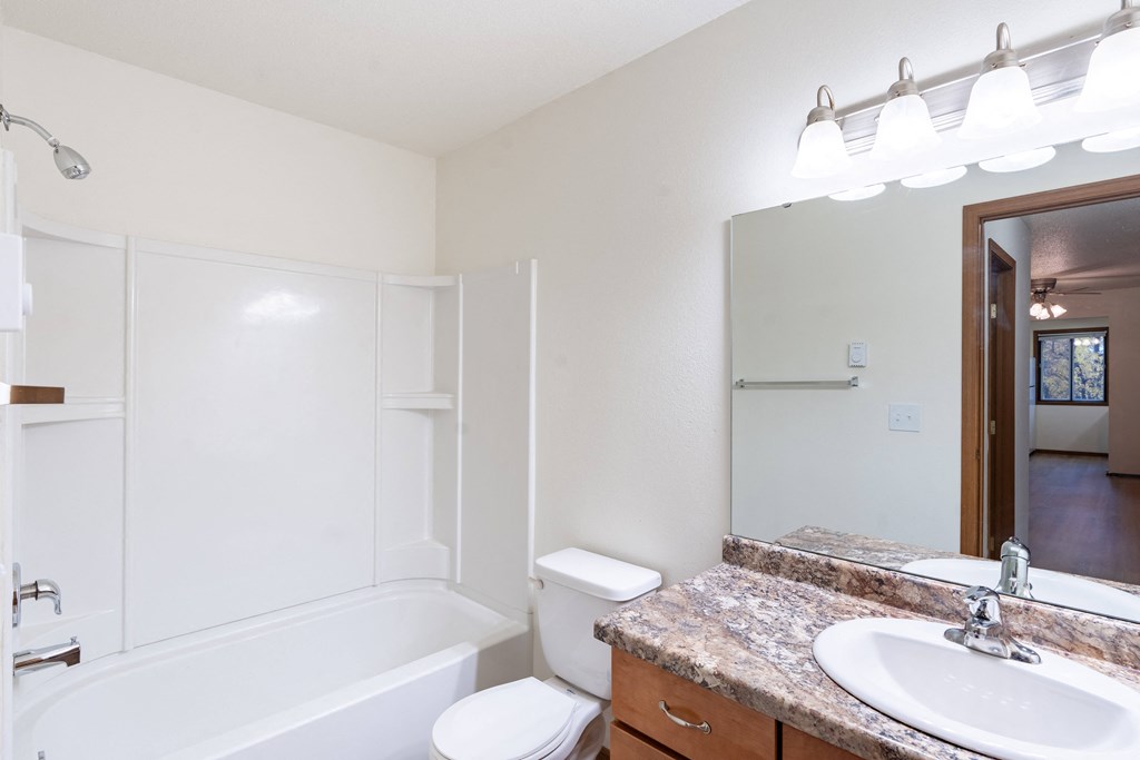 a bathroom with a sink and a toilet and a bath tub. Fargo, ND Flagstone Apartments