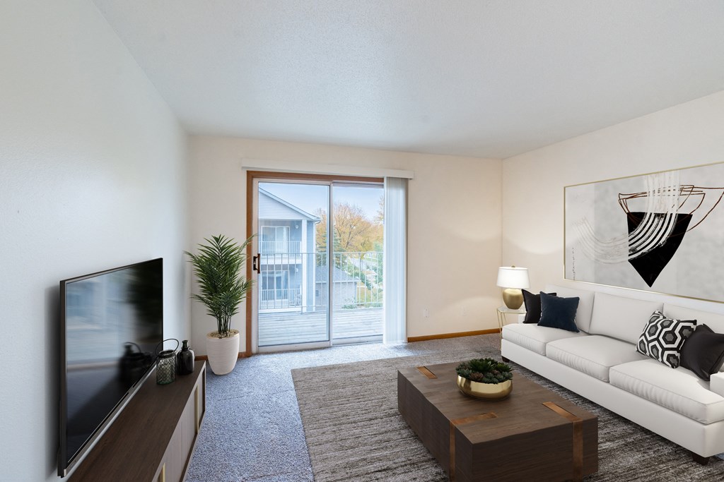 an open living room with a white couch and a tv and a sliding glass door. Fargo, ND Flagstone Apartments