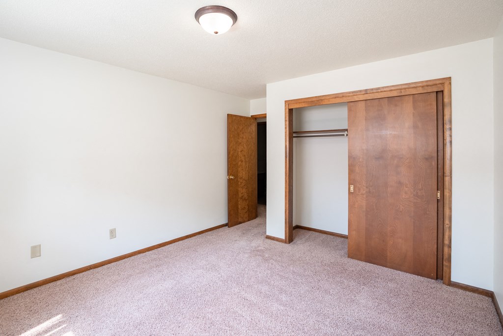 a bedroom with a closet and a door to a bathroom. Fargo, ND Hawn Apartments