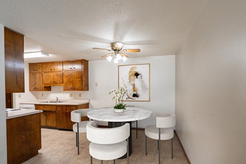 a kitchen and dining room with a table and chairs and a ceiling fan