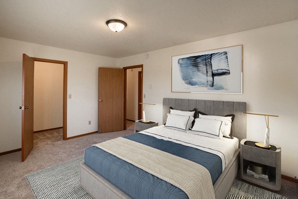 a bedroom with a bed and a door to a closet. Fargo, ND Hunters Run 2 Apartments