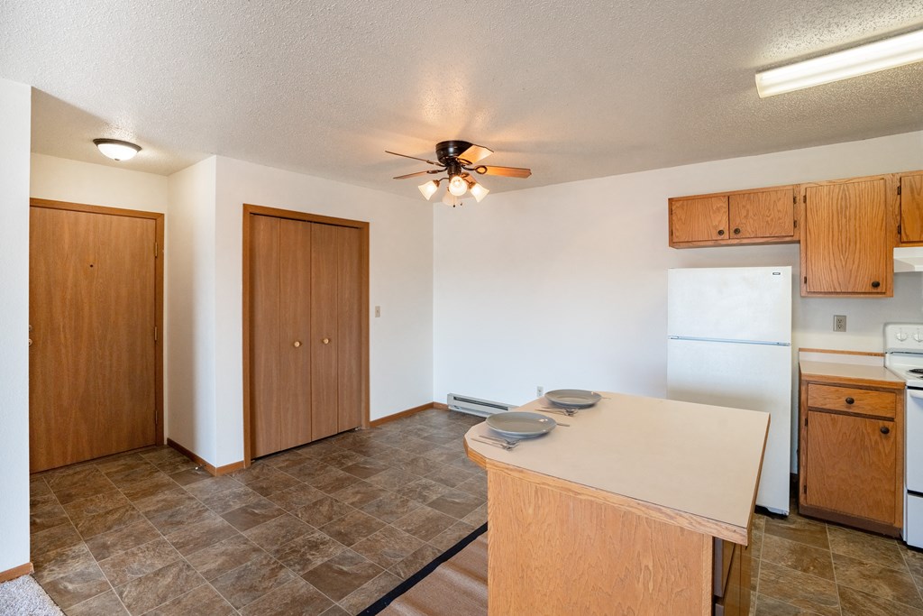 an empty kitchen with a island and a ceiling fan. Fargo, ND Hunters Run 2 Apartments