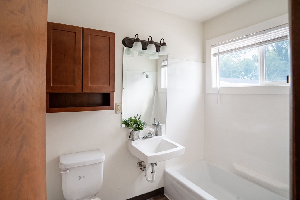a bathroom with a sink and a toilet and a bath tub. Fargo, ND Luxford Apartments