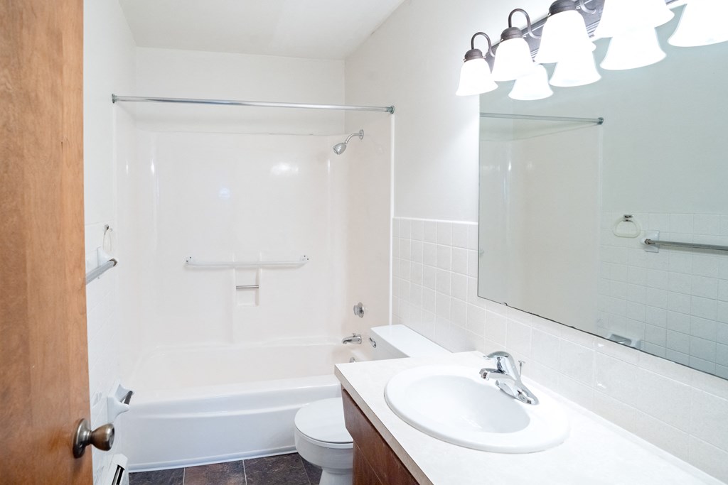 a bathroom with a sink and a shower and a toilet. Fargo, ND Martha Alice Apartments
