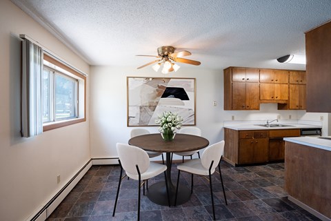 a kitchen and dining room with a table and chairs and a ceiling fan