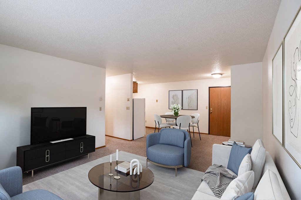 a living room with a couch and a table and a tv. Fargo, ND Monticello Apartments