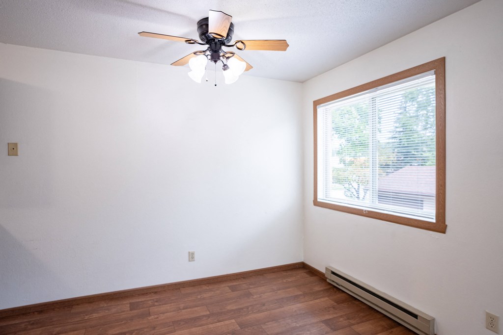 an empty room with a ceiling fan and a window. Fargo, ND Monticello Apartments