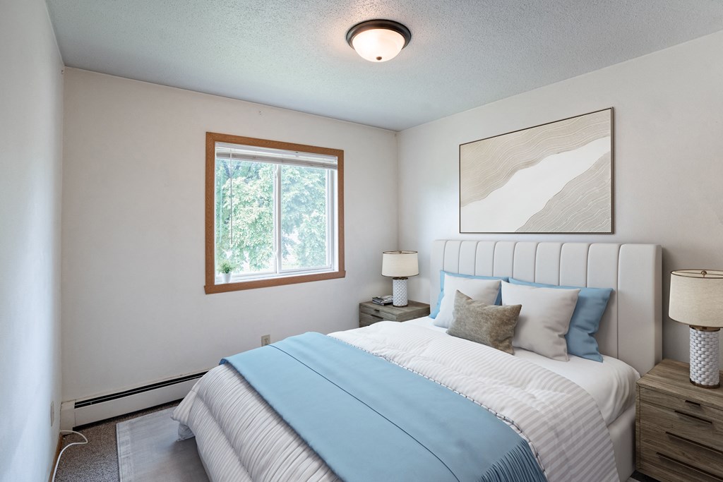a bedroom with a bed and a window. Fargo ND Morningside Apartments