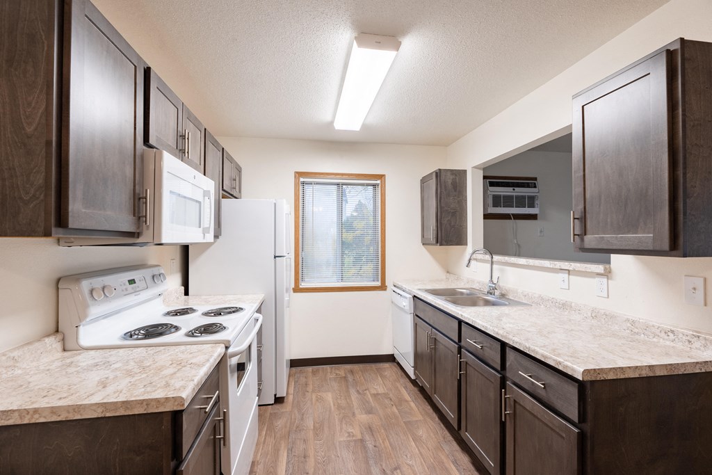 an apartment kitchen with white appliances. Fargo, ND Oxford Apartments