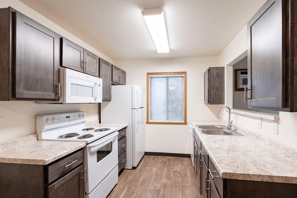 an apartment kitchen with white appliances. Fargo, ND Oxford Apartments