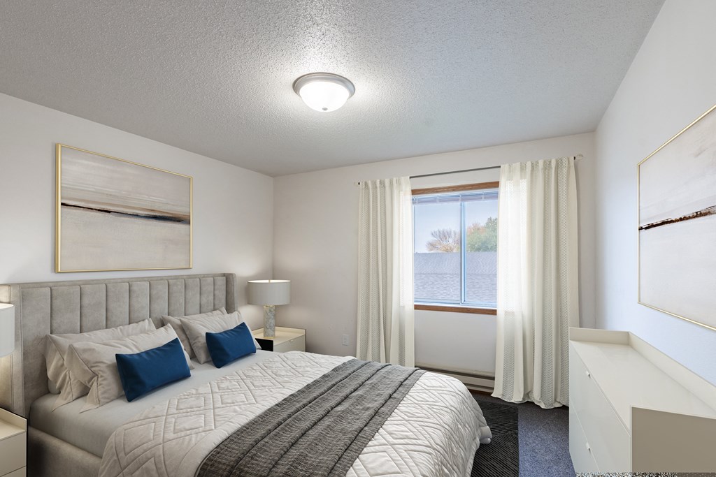 a bedroom with a large bed and a window. Fargo, ND Oxford Apartments